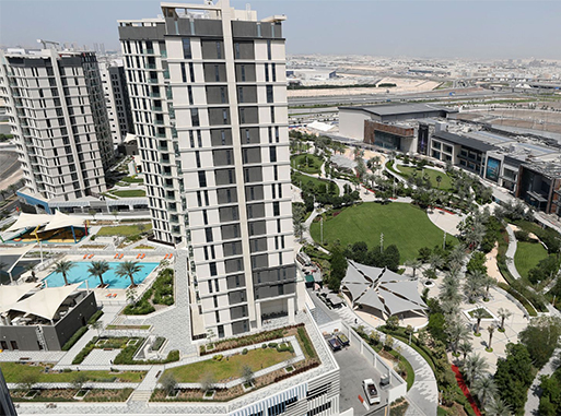 Aerial view of Expo Village residential towers and landscaped gardens in Dubai